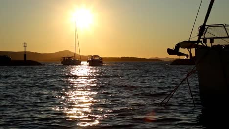 boats and yachts enter and exit marina at sunset in biograd in croatia