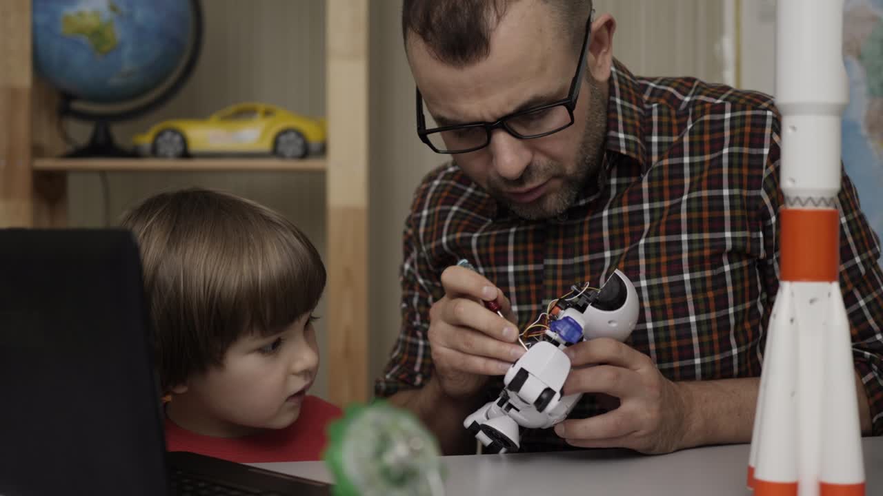 padre con hijo pequeño ensamblar robot en casa. educación ciencia, tecnología niños, programación electrónica robótica lección escolar. niño niño y maestro, ensamblar robots en el aula moderna.