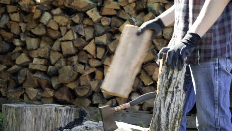 man chops log and sets it on a stack