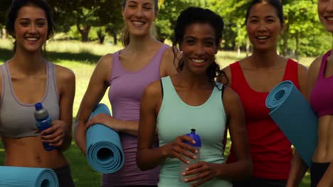 clase de fitness sonriendo a la cámara antes de su entrenamiento en el parque