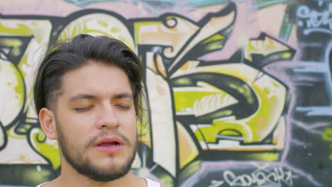 handsome guy drinking fresh water from a plastic bottle in a skate park