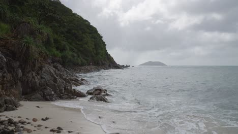 Wellen-Rollen-Am-Sandigen-Ufer-Mit-Felsigen-Bergen-In-Bai-Bang-Beach,-Vietnam