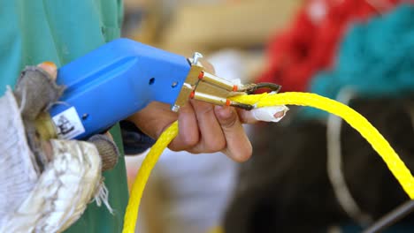 trabajador que utiliza una pistola de corte de cuerdas en la industria de fabricación de cuerdas 4k