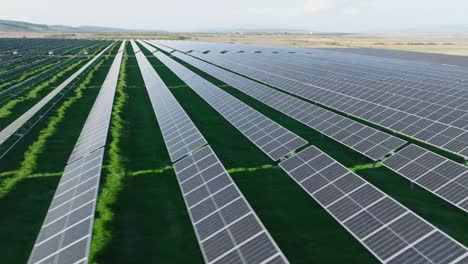 Rows-of-solar-panels-in-a-large-green-field-on-a-sunny-day