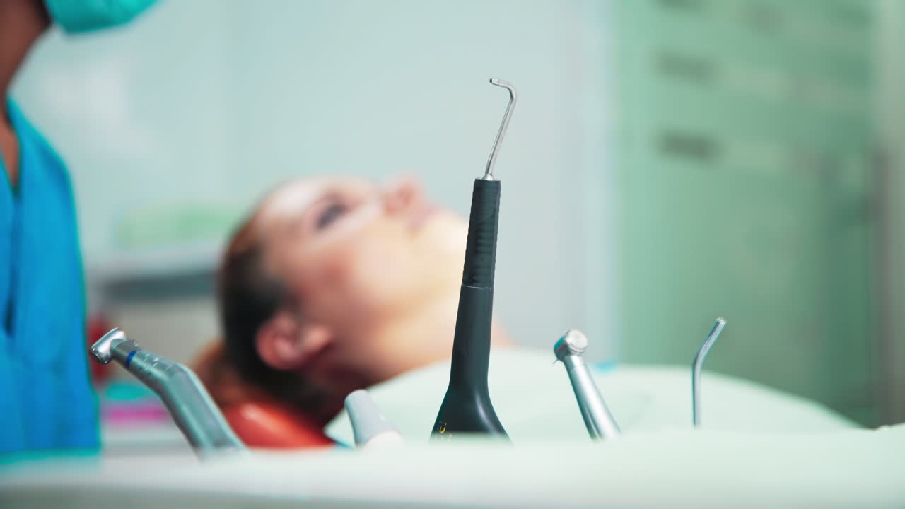 Doctor using a device in the dental office with patient at the examination