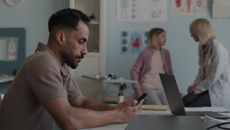 doctor consulting with patient and father using laptop in medical office