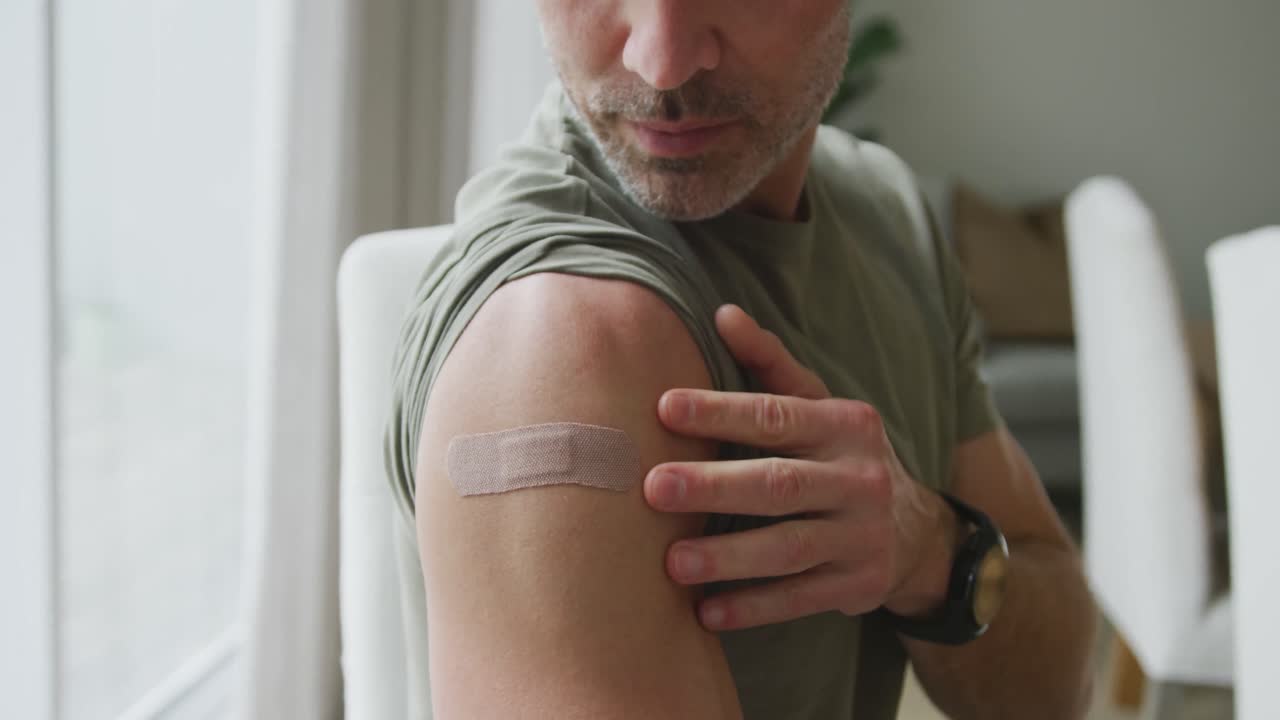 Ritratto di uomo caucasico con la spalla vaccinata a casa