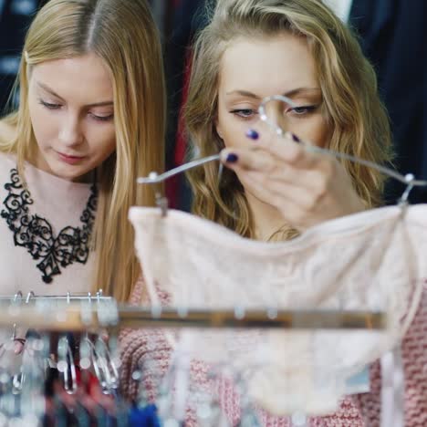 two friends choose warm winter clothes in the store 4