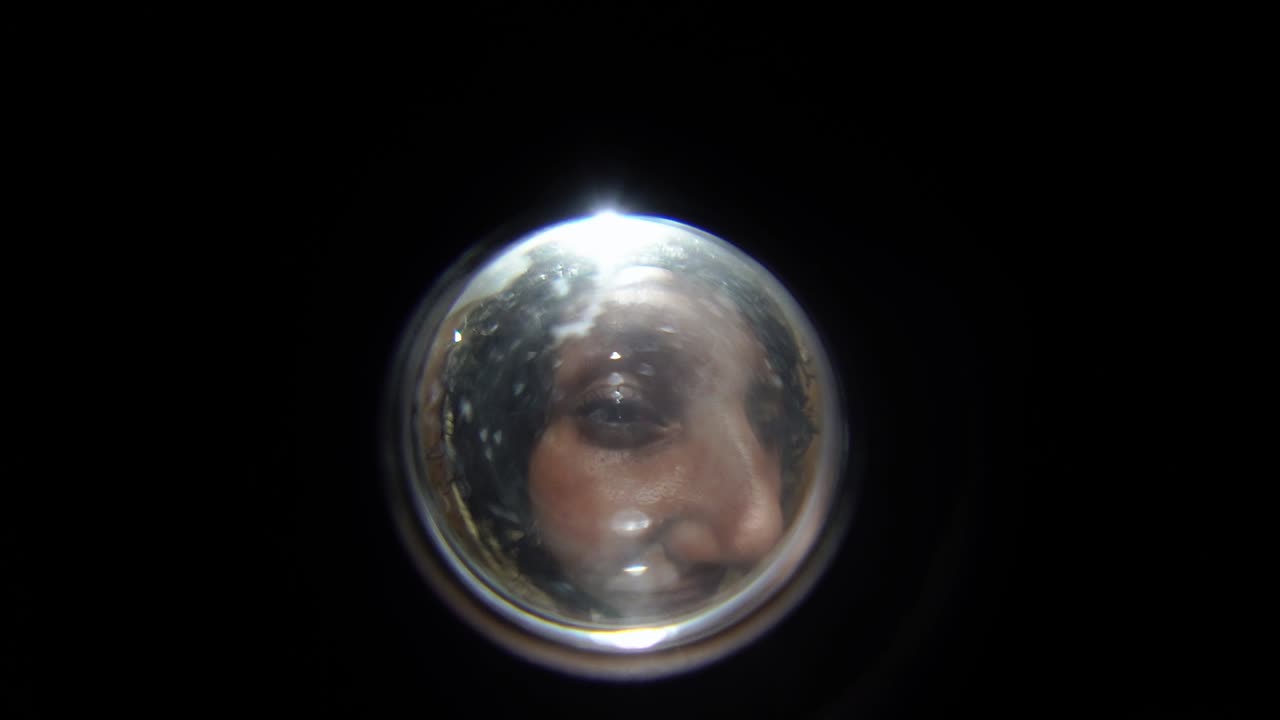 View of a woman standing in front of the door, view from the entrance door peephole