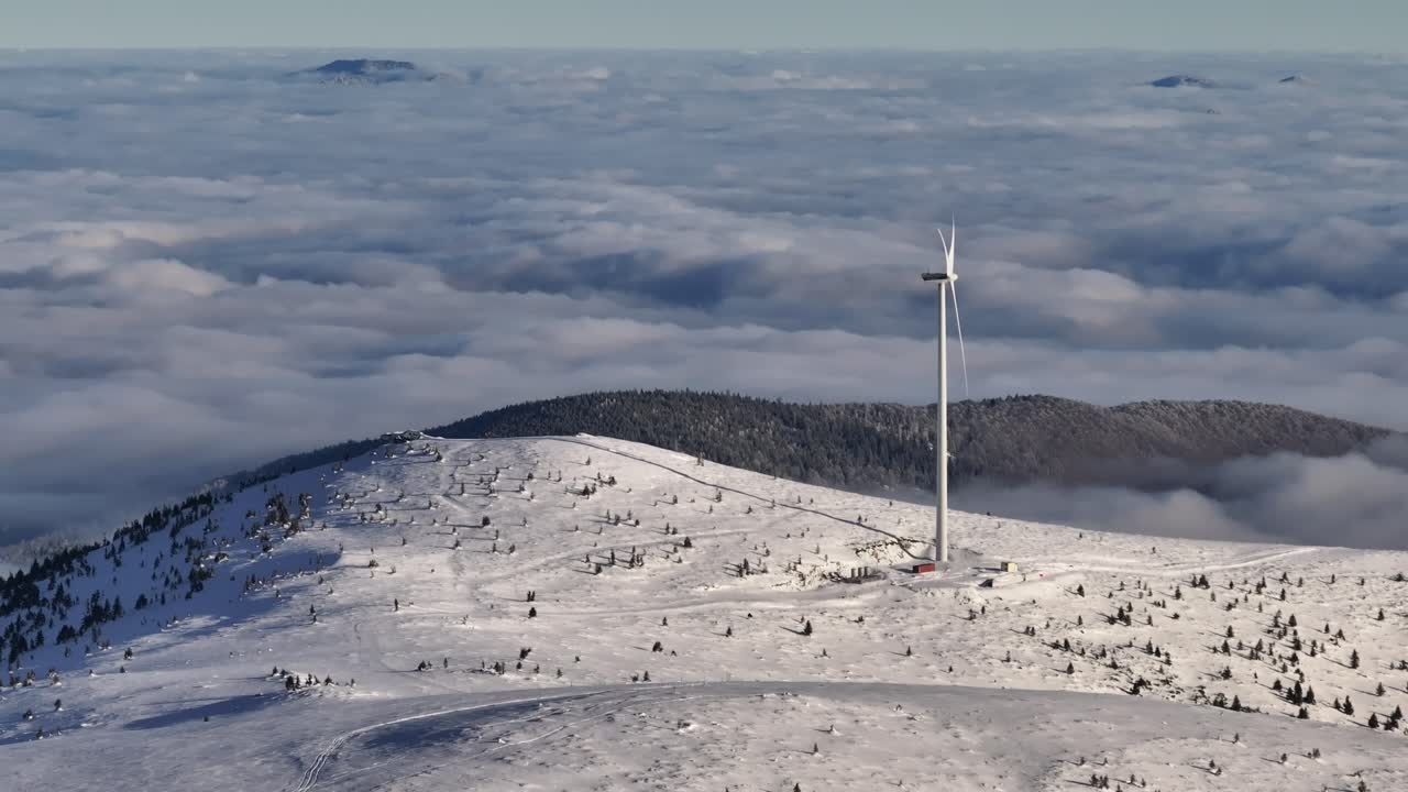 Wind turbines on top on the mountains above the clouds