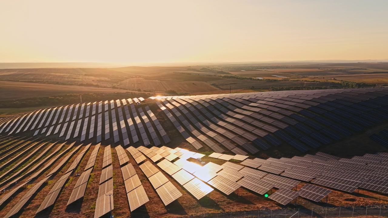 Luftfoto af solpanelpark ved solnedgang