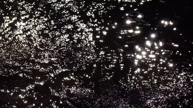 Scintillating sunlight reflects off of flowing creek water