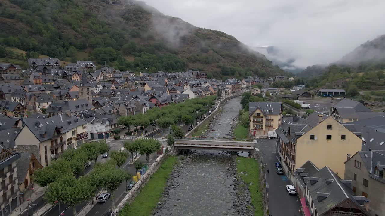 스페인의 피레네 산맥에 위치한 그림 같은 작은 마을의 강바닥을 가로질러 조용히 날아다니는 조용한 드론 촬영