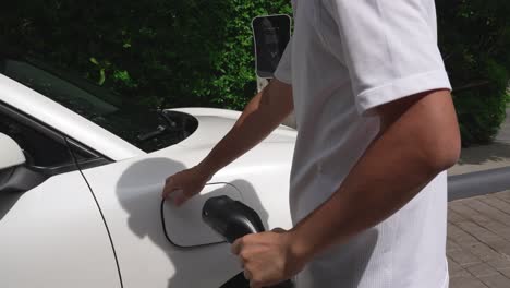 el hombre instaló el cable progresivo en su coche ev desde la estación de carga de su casa.