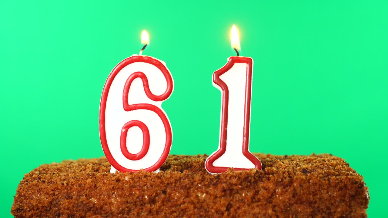 pastel con el número 61 vela encendida. llave de croma. pantalla verde. aislado