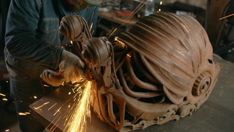 metal sculptor working on a rusty robot head