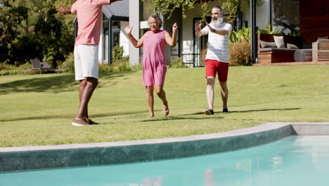 friends reuniting by pool, embracing and smiling in outdoor setting