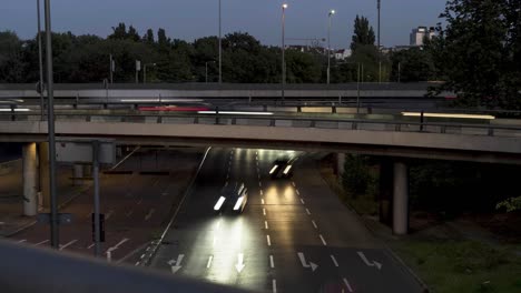 timelapse of cars on highway in germany at night, headlights coming at camera, bridge across road with cars passing by