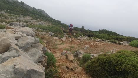 un excursionista que lleva equipo de camping se aleja en un terreno abierto con una pendiente suave en el camino de licia en turquía