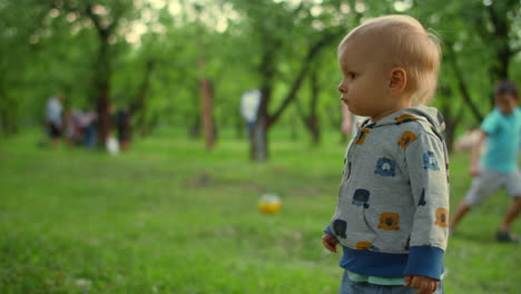 close-up view of focused toddler standing outside