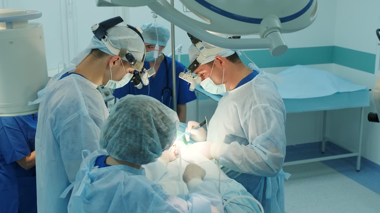 los cirujanos realizan una operación y miran a través de un microscopio móvil