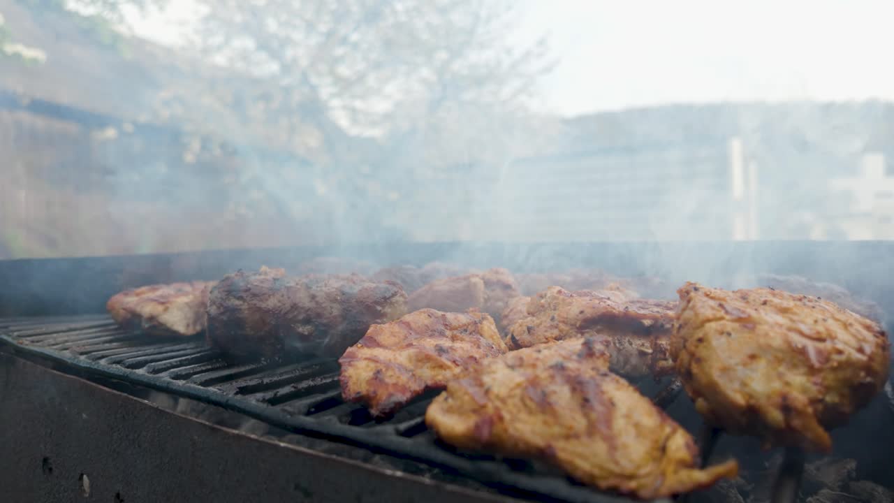 Slowmotion video of meat cooking on a grill with smoke