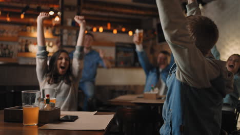 a group of men and women in a pub together cheer for their national team at the world cup in football basketball hockey. celebrate the goal scored the puck. celebrate a victory a beaten penalty