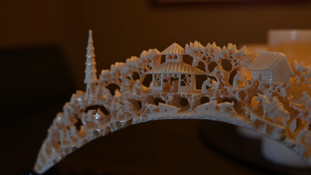 따뜻한 촛불 빛은 출처를 알 수 없는 동물의 상아 조각을 비춥니다