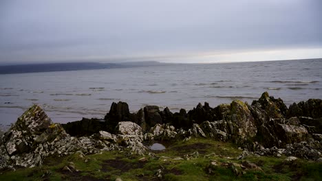 Vista-De-Las-Olas-Del-Mar-En-El-Océano,-Hierba-Verde-Y-Rocas-En-Dundalk,-Irlanda