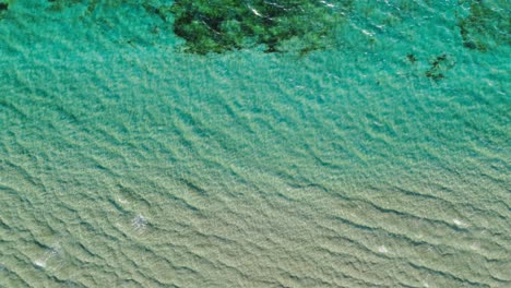 Von-Oben-Nach-Unten-Antenne-Von-Türkisblauen-Meereswellen,-Die-Gegen-Den-Sommerstrand-Krachen