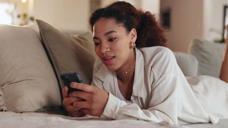 mujer joven relajándose en el sofá y usando un teléfono inteligente