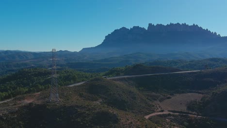 road crosses bosc de les creus with montserrat mountain in background