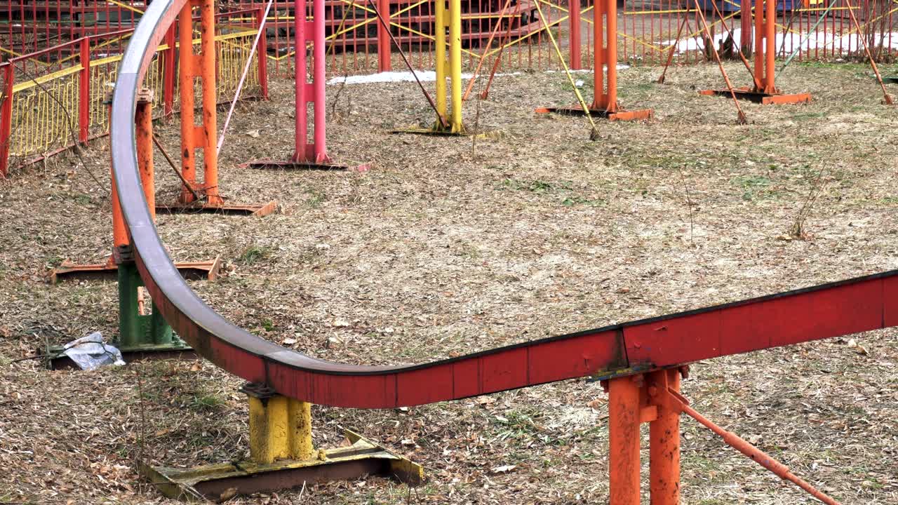 closeup A colorful attraction rides people on the rails in the amusement park in the spring. A rainbow attraction is taken a ride on in the open air.