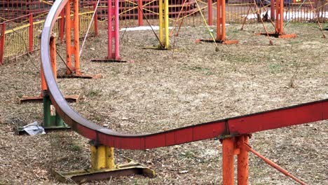 en primer plano una atracción colorida monta a la gente en los rieles en el parque de atracciones en la primavera. una atracción arco iris se lleva a un paseo al aire libre.