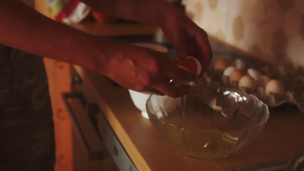 primer plano de una persona separando la clara de la yema al romper un huevo