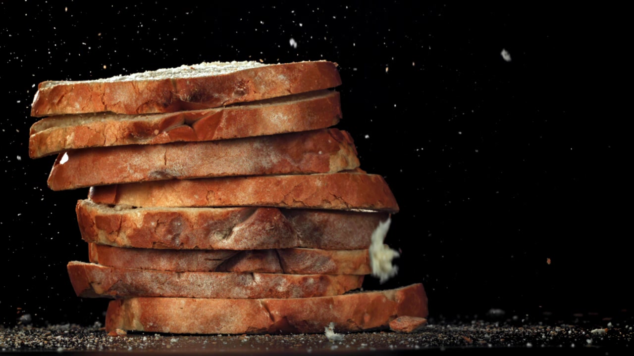 Slow Motion of Bread Crumbs Falling on a Stack of Sliced Bread