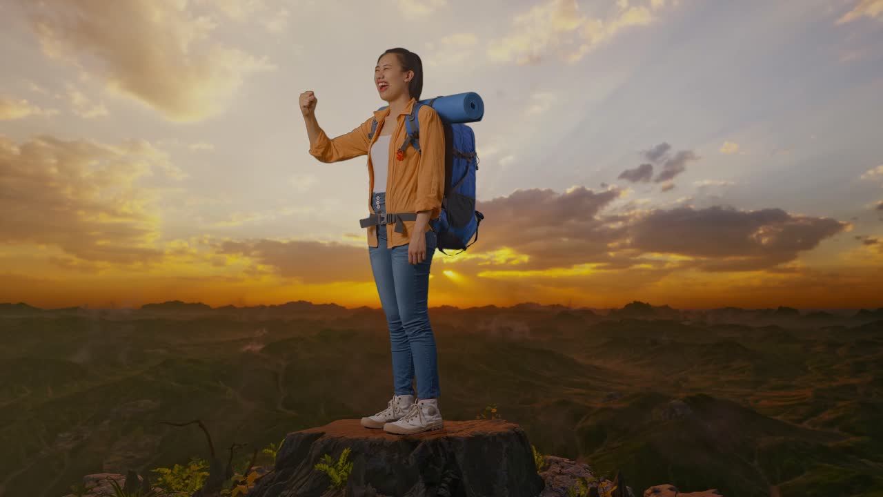 vista lateral completa del cuerpo de una excursionista asiática con mochila de montañismo gritando meta celebrando el éxito mientras está de pie en la cima de la montaña durante el atardecer