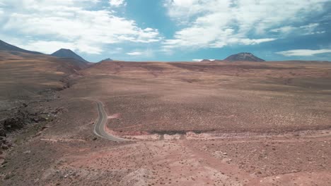 Drone-panning-in-the-sky-over-a-highway-on-the-Chilean-desert