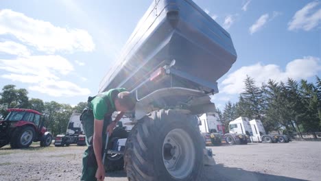 farmer mechanic repairing tractor. open tractor hood, engine. repair agricultural technology