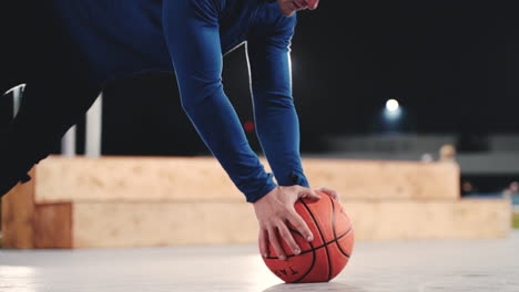 Sportive-Blond-Man-Doing-Push-Ups-Using-Basketball-In-The-Park-At-Night