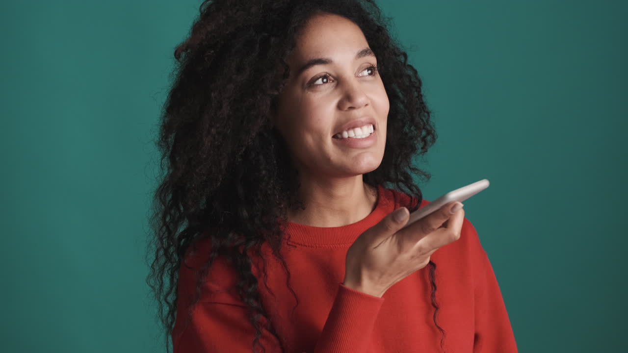 African american woman using smartphone over blue background.