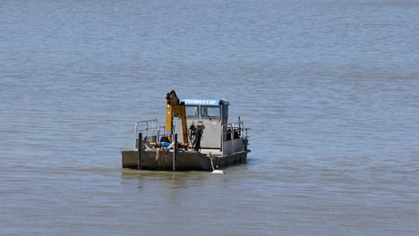 a boat with crane moving on water