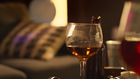 close up of wine glasses and beer bottles on table after house party 2