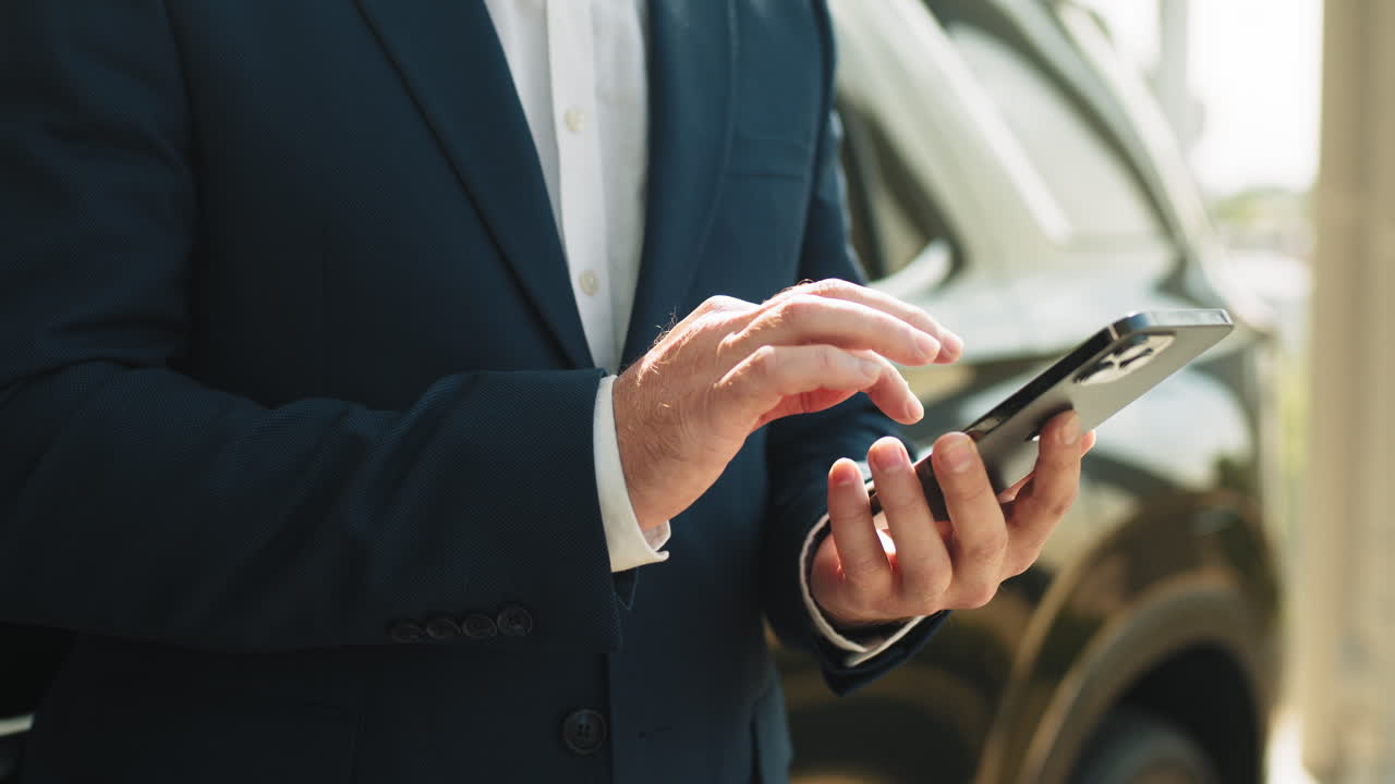 hombre de negocios usando teléfono inteligente cerca del coche
