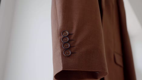 wedding preparations, a close-up of the cuff buttons on the suit jacket hanging on a hanger, waiting for the groom