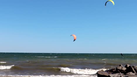 Practicantes-De-Kitesurf-En-Un-Hermoso-Día-Prácticamente-Despejado-Atravesando-La-Costa