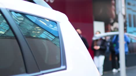 people interacting near a parked car