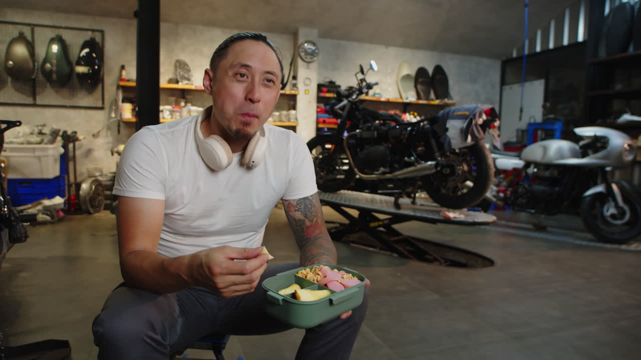 Multicultural Biker Having Lunch in Motorcycle Garage