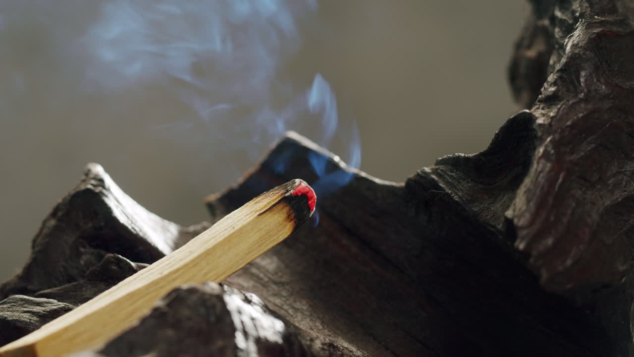 Person holding Palo Santo wood stick in hand, aromatic Palo Santo burning on black background, smoke spreading around, slow motion video clip, high quality 4k close up footage. High quality 4k footage