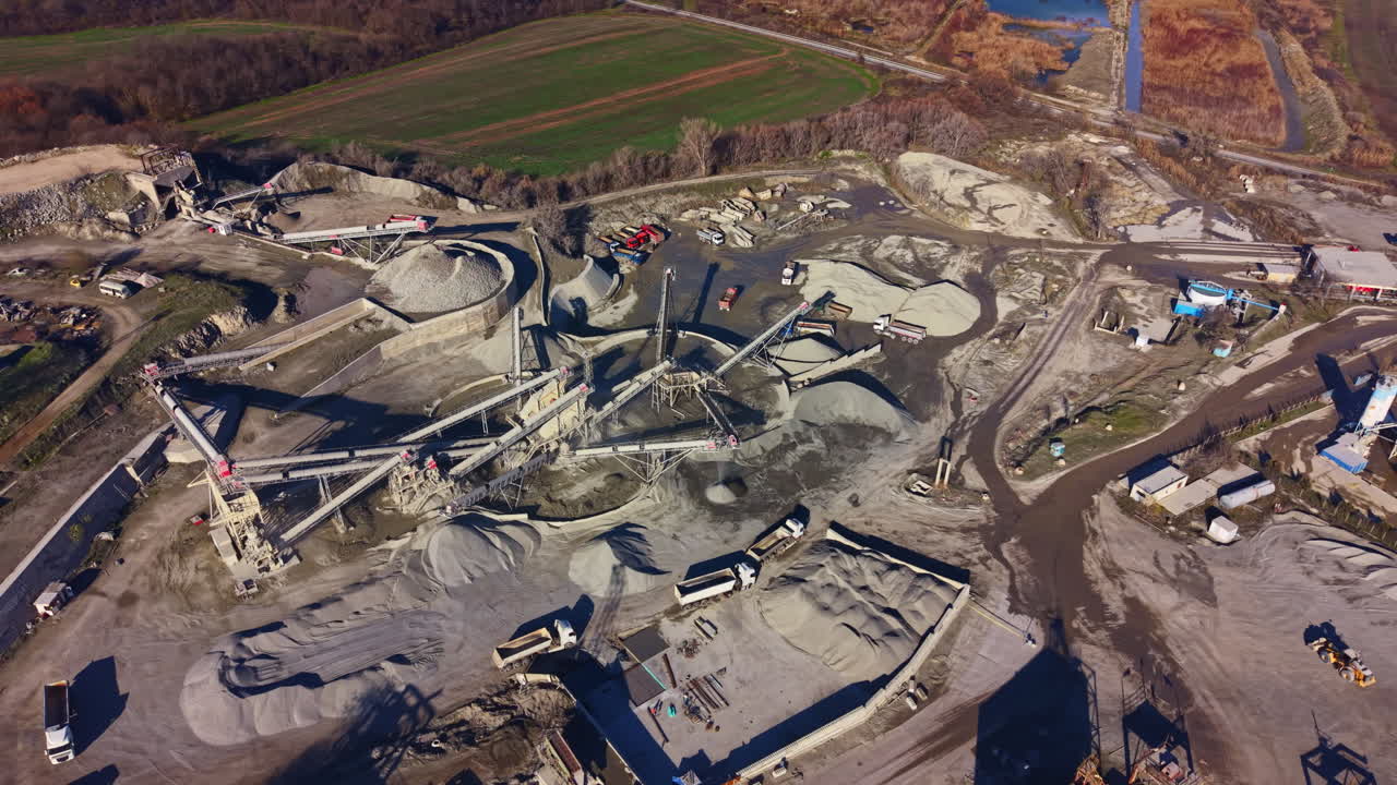 Industrial landscape of a gravel quarry in operation showcasing machinery and materials on a bright sunny day